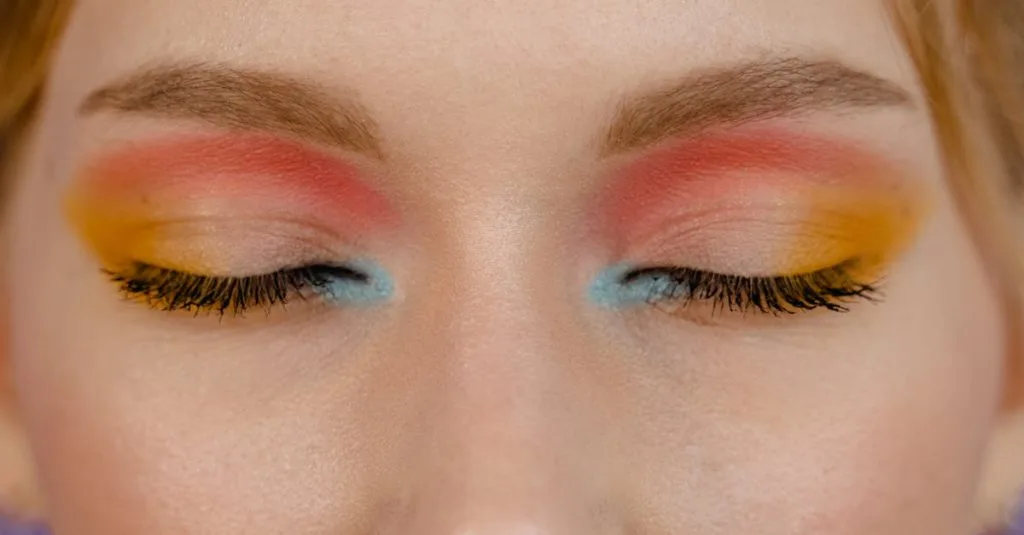 Close-up of a woman's closed eyes showcasing vibrant multicolored eye makeup.